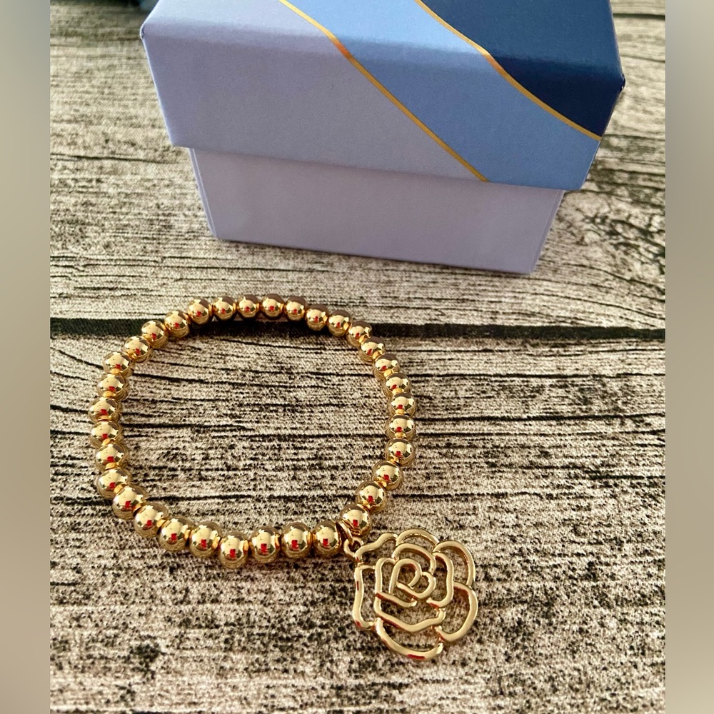New in box. Gorgeous stretchy beaded bracelet with camellia charm